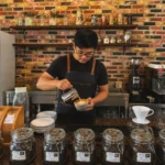 A barista pouring latte art into a cup at the espresso bar of Wondellea Cafe & Resort, a premium specialty cafe in Cavite - Best Places for Coffee
