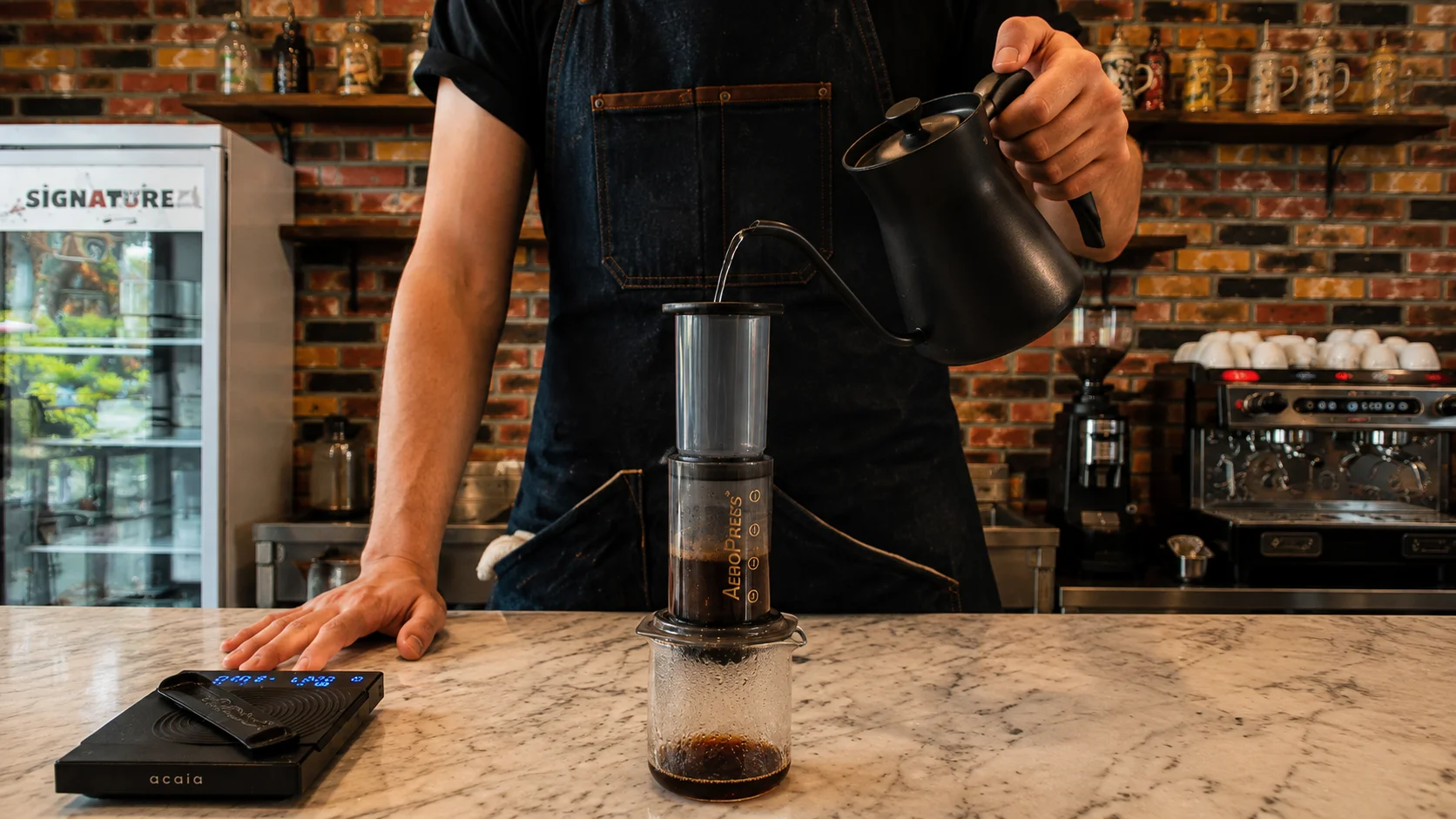Barista pouring hot water into AeroPress at the best coffee shop in Cavite