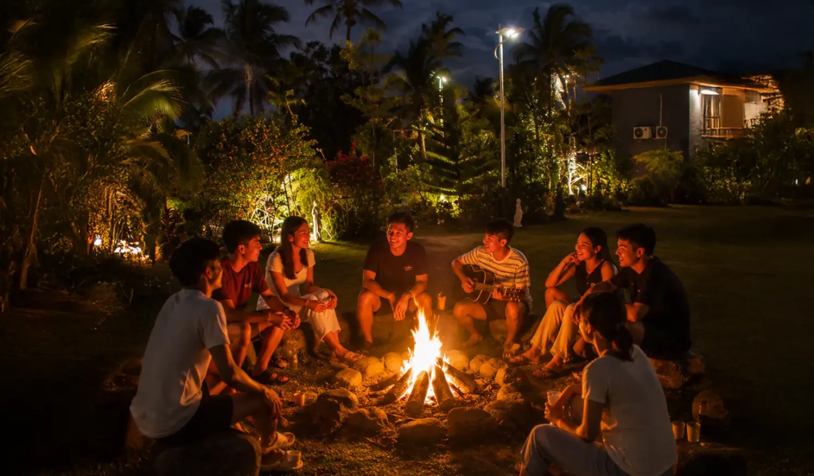 Guests gathered around a glowing stone fire pit during the evening in the relaxing camp fire area at Wondellea