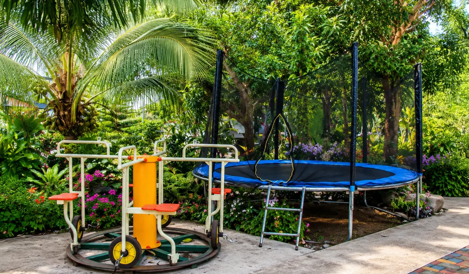 Outdoor children's playground with a trampoline and merry-go-round at Wondellea