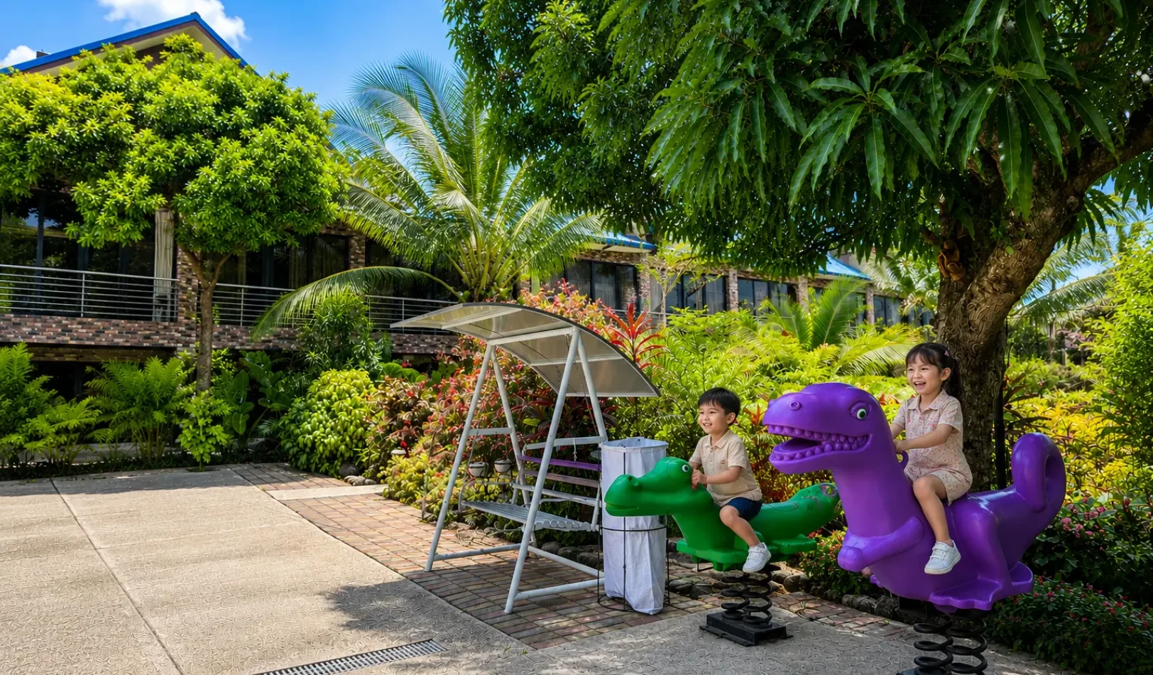 An outdoor play ground area with swings, climbing structures, and colorful pavement tiles at Wondellea